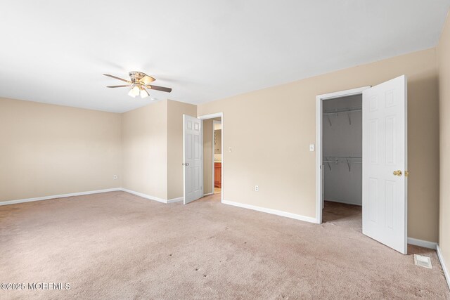 7 Sloop Sq, Freehold, NJ 07728 - unfurnished bedroom featuring light carpet, baseboards, a walk in closet, a ceiling fan, and a closet