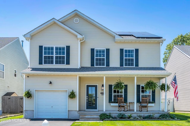 28 Dolphin Cir W, Bayville, NJ 08721 - view of front facade with covered porch, a garage, solar panels, and driveway