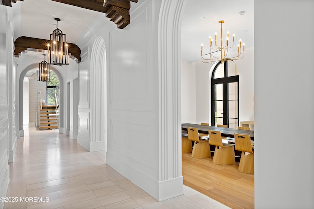 27 N Ward Ave, Rumson, NJ 07760 - corridor with a chandelier, arched walkways, a decorative wall, light wood finished floors, and beam ceiling