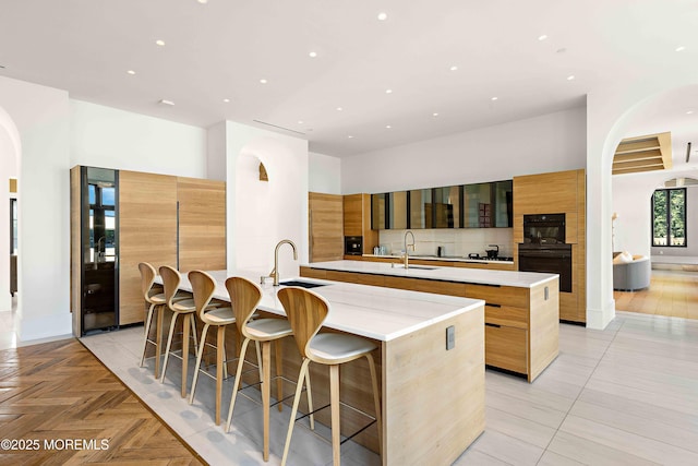 27 N Ward Ave, Rumson, NJ 07760 - kitchen featuring a large island, modern cabinets, a sink, arched walkways, and recessed lighting