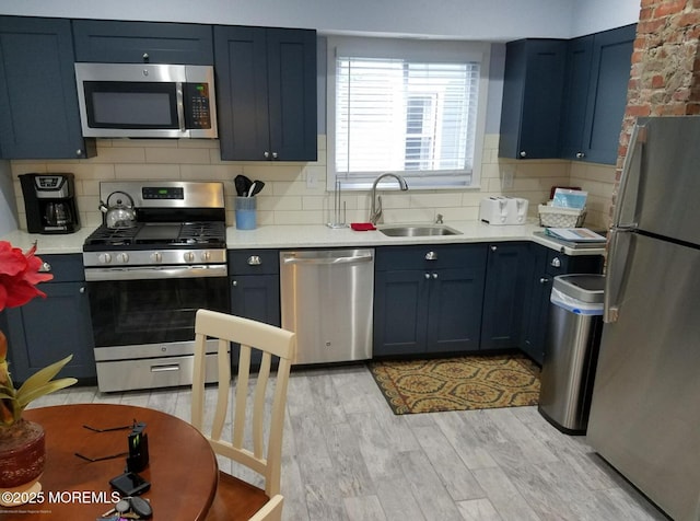 1102 5th Ave, Asbury Park, NJ 07712 - kitchen featuring appliances with stainless steel finishes, a sink, light countertops, backsplash, and light wood-style flooring