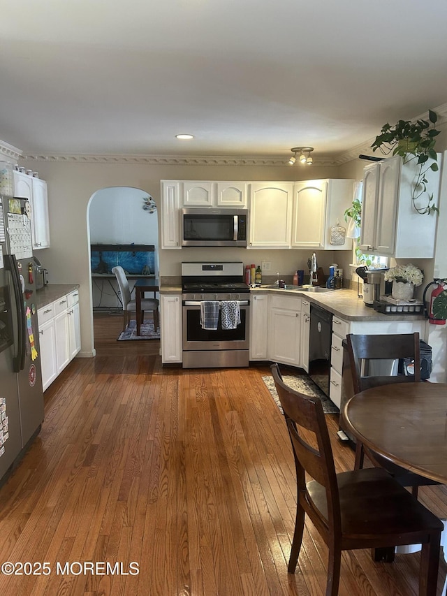 516 Montgomery Ave, Toms River, NJ 08757 - kitchen featuring appliances with stainless steel finishes, arched walkways, dark wood-style floors, and white cabinets