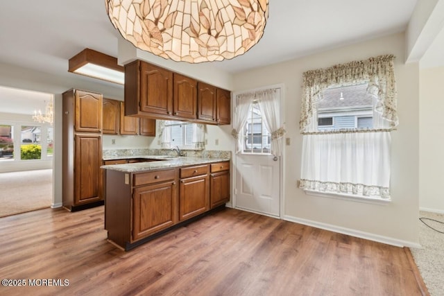 1524 Quince Pl, Toms River, NJ 08755 - kitchen with brown cabinetry, light countertops, wood finished floors, a sink, and a peninsula