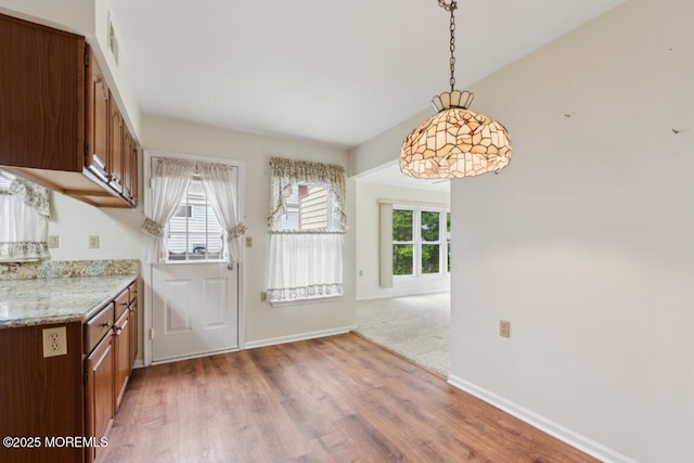 1524 Quince Pl, Toms River, NJ 08755 - kitchen featuring light wood-style floors, brown cabinets, baseboards, decorative light fixtures, and light stone countertops