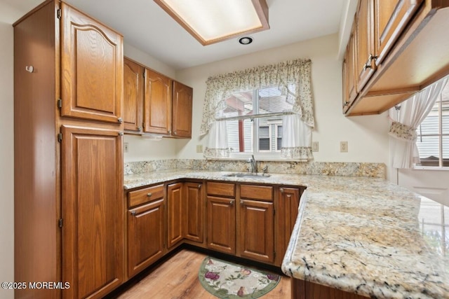 1524 Quince Pl, Toms River, NJ 08755 - kitchen featuring a sink, brown cabinetry, light stone counters, and light wood-type flooring