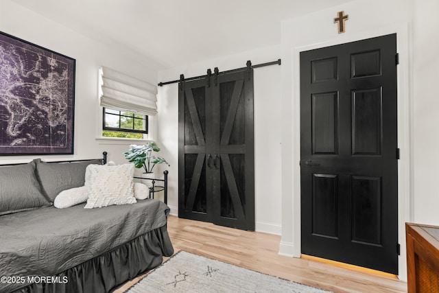 7 Carlisle Ct, Hazlet, NJ 07730 - bedroom featuring a barn door, wood finished floors, and baseboards