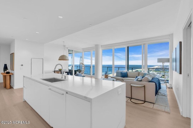 1101 Ocean Ave Unit 1403, Asbury Park, NJ 07712 - kitchen featuring a sink, light wood finished floors, a kitchen island with sink, white cabinetry, and modern cabinets