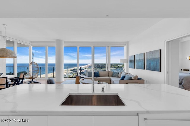 1101 Ocean Ave Unit 1403, Asbury Park, NJ 07712 - kitchen featuring open floor plan, light stone countertops, a water view, and a sink