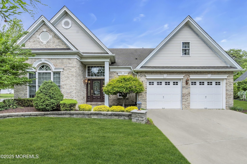 1 Lattimore Ct, Freehold, NJ 07728 - view of front facade featuring concrete driveway, a front lawn, brick siding, and an attached garage