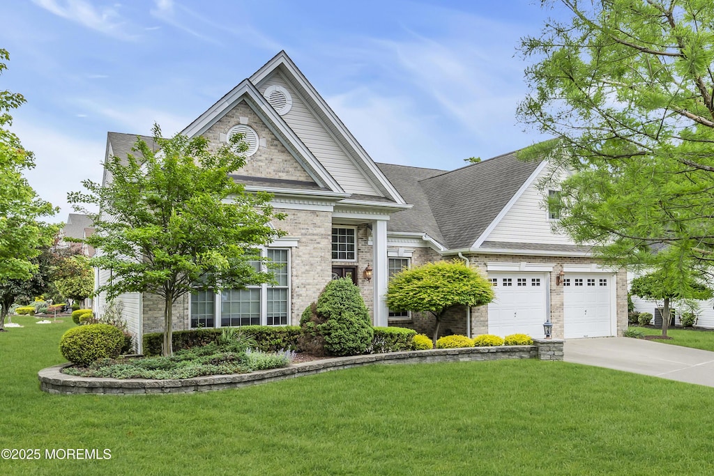 1 Lattimore Ct, Freehold, NJ 07728 - greek revival house featuring concrete driveway, a front lawn, brick siding, an attached garage, and roof with shingles