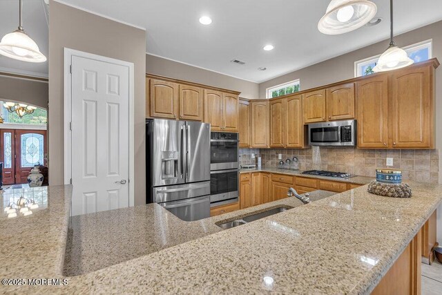 1 Lattimore Ct, Freehold, NJ 07728 - kitchen featuring appliances with stainless steel finishes, a sink, light stone counters, backsplash, and plenty of natural light