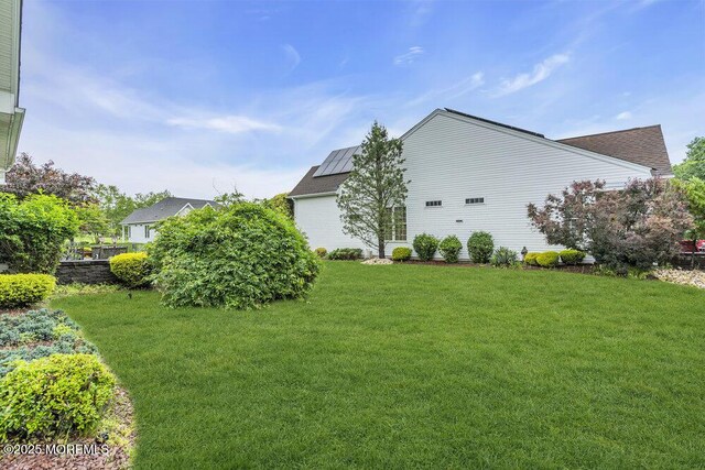 1 Lattimore Ct, Freehold, NJ 07728 - view of property exterior with a lawn and roof mounted solar panels