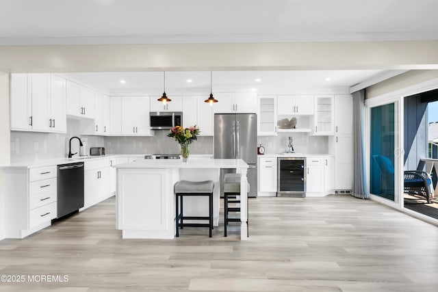 J4 Twinlights Ct, Highlands, NJ 07732 - kitchen featuring stainless steel appliances, wine cooler, light wood-style floors, a breakfast bar, and white cabinets
