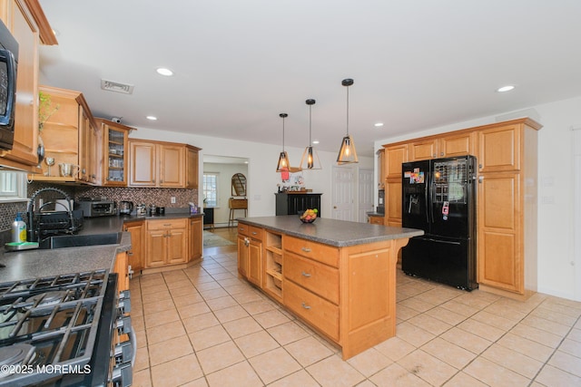 209 Woodcrest Rd, Oakhurst, NJ 07755 - kitchen featuring black fridge, dark countertops, backsplash, a center island, and light tile patterned floors