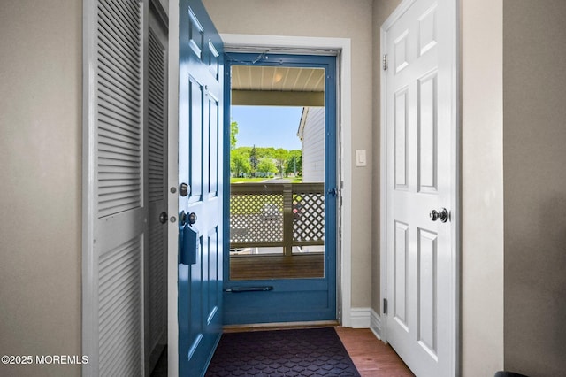 doorway to outside featuring wood finished floors and baseboards