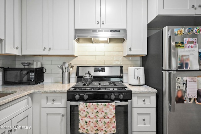 kitchen featuring appliances with stainless steel finishes, under cabinet range hood, tasteful backsplash, white cabinets, and light stone counters