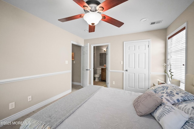 carpeted bedroom featuring baseboards, connected bathroom, and ceiling fan