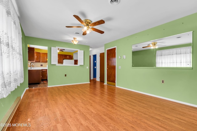 11 Lexington Dr Unit A, Whiting, NJ 08759 - unfurnished living room featuring ceiling fan, light wood finished floors, a sink, and baseboards
