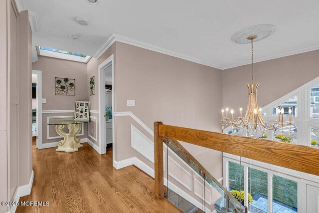 3504 Churchill Dr, Toms River, NJ 08753 - corridor with an upstairs landing, wood finished floors, a chandelier, crown molding, and a skylight