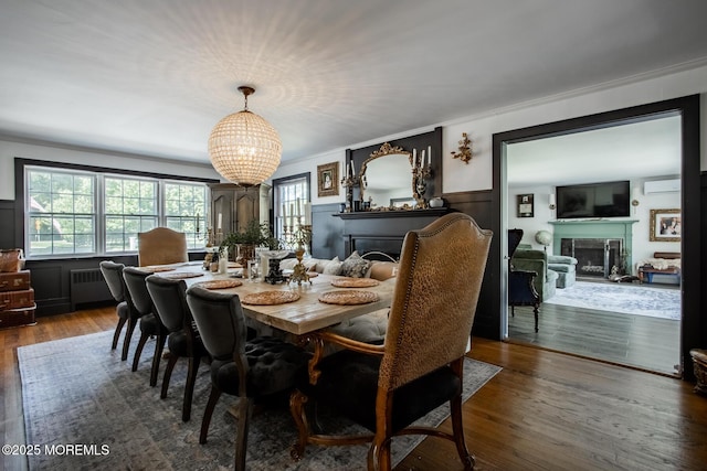 135 Rumson Rd, Rumson, NJ 07760 - dining area with a fireplace, a chandelier, crown molding, radiator, and wood finished floors