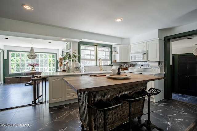 135 Rumson Rd, Rumson, NJ 07760 - kitchen with butcher block counters, white microwave, a kitchen breakfast bar, tasteful backsplash, and stove