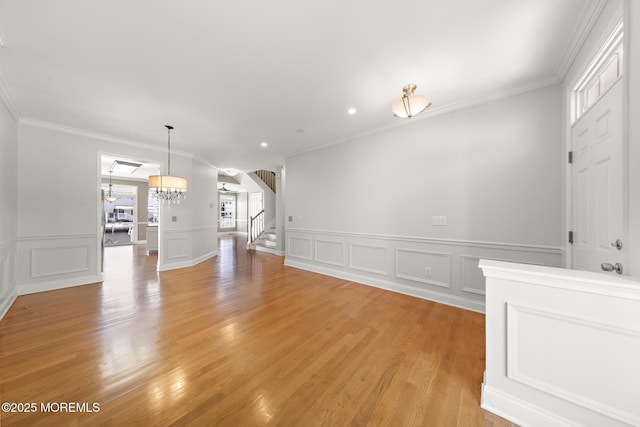 14 Osprey Ln Unit 72, Bayville, NJ 08721 - unfurnished room with crown molding, stairway, a chandelier, a decorative wall, and light wood-style floors