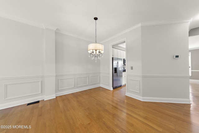 14 Osprey Ln Unit 72, Bayville, NJ 08721 - unfurnished dining area featuring a chandelier, light wood finished floors, crown molding, and a wainscoted wall
