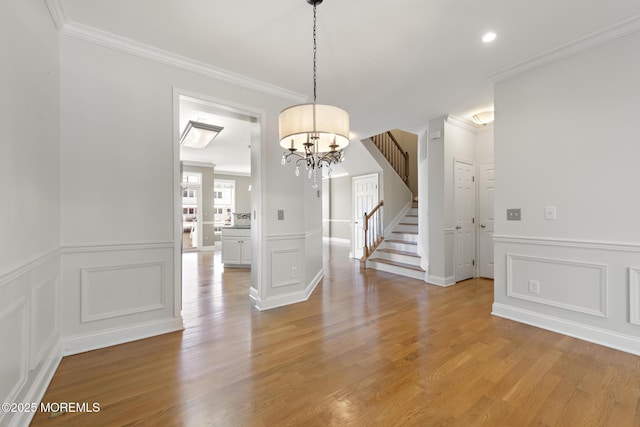14 Osprey Ln Unit 72, Bayville, NJ 08721 - unfurnished dining area featuring a decorative wall, stairs, a chandelier, ornamental molding, and light wood-style flooring