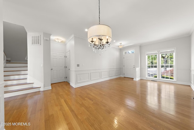 14 Osprey Ln Unit 72, Bayville, NJ 08721 - unfurnished dining area with crown molding, light wood-type flooring, stairway, a chandelier, and wainscoting