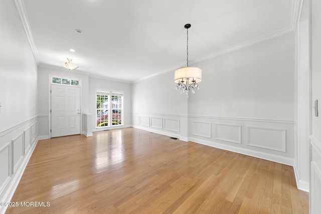 14 Osprey Ln Unit 72, Bayville, NJ 08721 - unfurnished dining area with crown molding, a chandelier, a decorative wall, light wood-type flooring, and wainscoting
