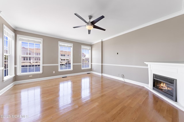 14 Osprey Ln Unit 72, Bayville, NJ 08721 - unfurnished living room with plenty of natural light, light wood-style flooring, ornamental molding, a ceiling fan, and a glass covered fireplace