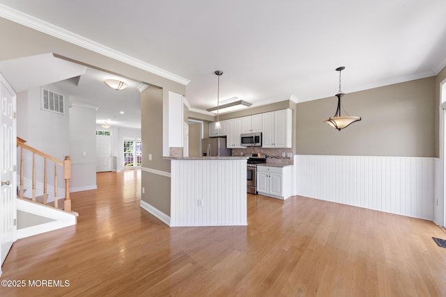 14 Osprey Ln Unit 72, Bayville, NJ 08721 - kitchen with stainless steel appliances, light wood-type flooring, white cabinetry, decorative backsplash, and hanging light fixtures