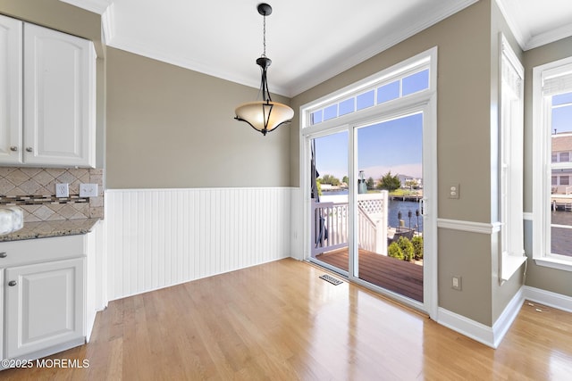 14 Osprey Ln Unit 72, Bayville, NJ 08721 - unfurnished dining area with ornamental molding, light wood-type flooring, a water view, and plenty of natural light