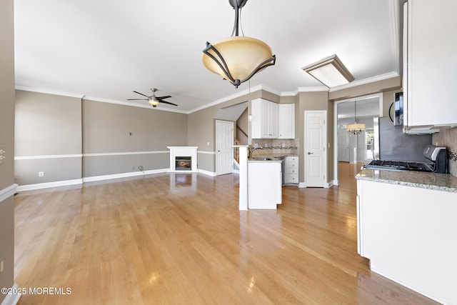 14 Osprey Ln Unit 72, Bayville, NJ 08721 - kitchen with stainless steel microwave, ceiling fan, range with gas cooktop, white cabinetry, and backsplash