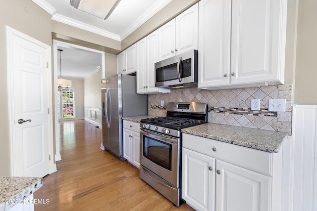14 Osprey Ln Unit 72, Bayville, NJ 08721 - kitchen featuring appliances with stainless steel finishes, crown molding, white cabinets, light wood-style flooring, and light stone counters