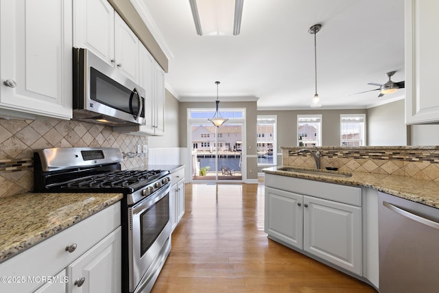 14 Osprey Ln Unit 72, Bayville, NJ 08721 - kitchen featuring stainless steel appliances, a sink, white cabinets, ornamental molding, and decorative backsplash