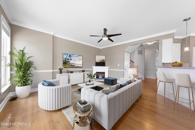 14 Osprey Ln Unit 72, Bayville, NJ 08721 - living area featuring light wood-style flooring, a ceiling fan, a glass covered fireplace, and crown molding
