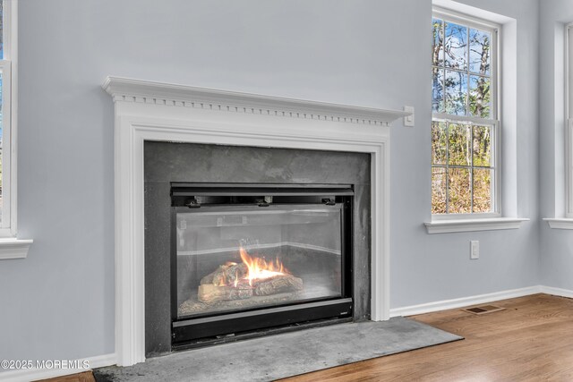 19 Hillside Ave, Barnegat, NJ 08005 - detailed view of a warm lit fireplace, wood finished floors, and baseboards