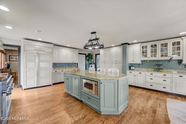 68 Seneca Pl, Oceanport, NJ 07757 - kitchen featuring stainless steel appliances, white cabinetry, light wood-style floors, recessed lighting, and a kitchen island with sink