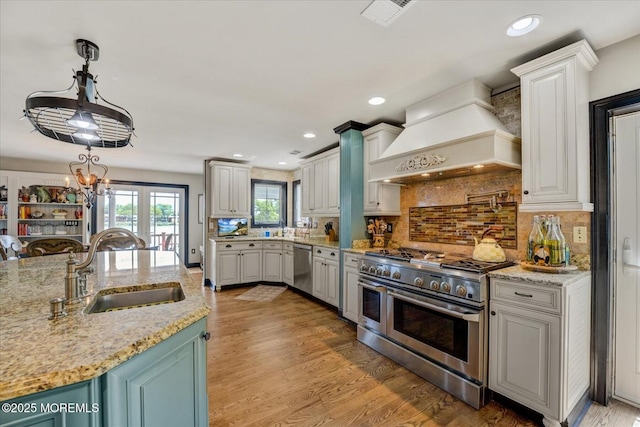 68 Seneca Pl, Oceanport, NJ 07757 - kitchen featuring custom exhaust hood, stainless steel appliances, a sink, backsplash, and light wood-style floors