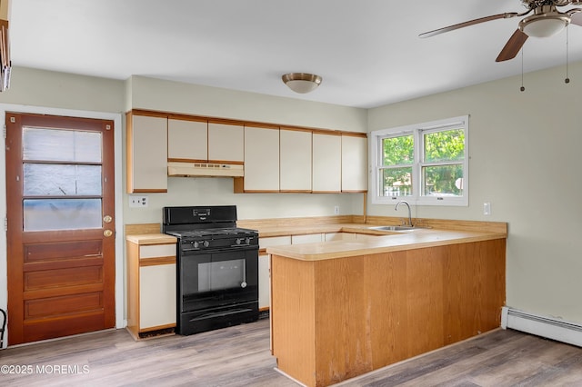90 Dock Rd, Brick, NJ 08723 - kitchen with black gas range oven, under cabinet range hood, ceiling fan, a baseboard radiator, and light countertops