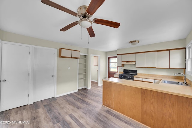 90 Dock Rd, Brick, NJ 08723 - kitchen featuring black range with gas cooktop, under cabinet range hood, a peninsula, light countertops, and wood finished floors
