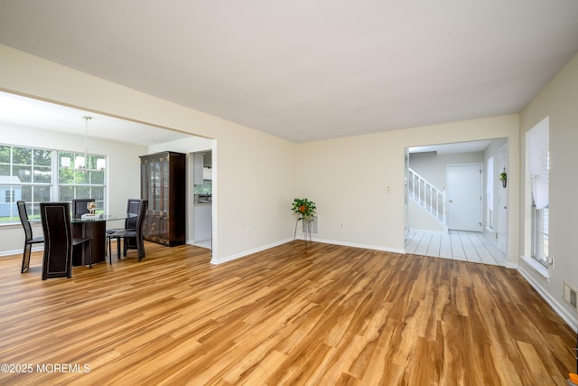 14 Winfield Dr, Manalapan, NJ 07726 - unfurnished living room with a chandelier, light wood-type flooring, stairway, and baseboards