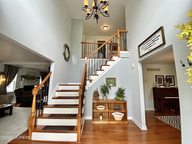 8 Augusta St, Wrightstown, NJ 08562 - stairs featuring a towering ceiling, a chandelier, wood finished floors, baseboards, and a fireplace