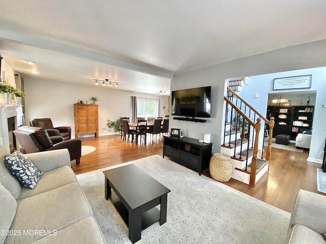 8 Augusta St, Wrightstown, NJ 08562 - living area with wood finished floors, stairs, a fireplace, and a chandelier