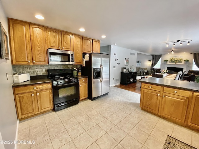 8 Augusta St, Wrightstown, NJ 08562 - kitchen with stainless steel appliances, dark countertops, light tile patterned flooring, decorative backsplash, and brown cabinets