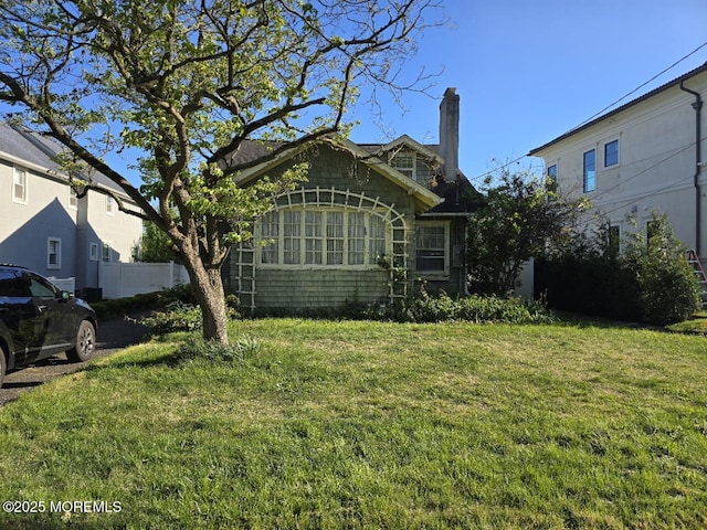 view of property exterior with a chimney and a yard