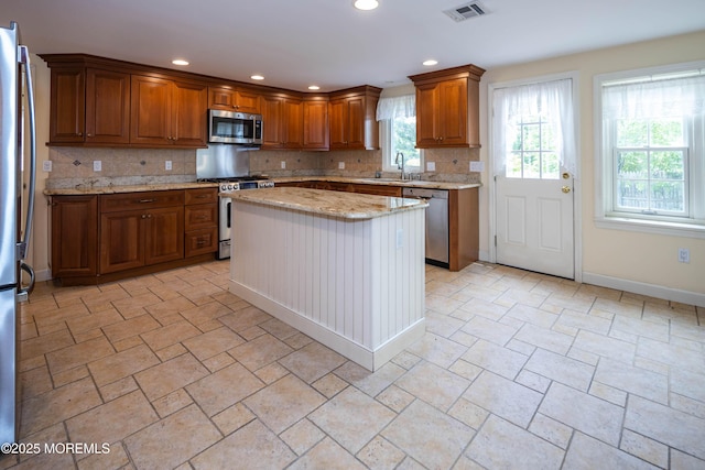 153 12th St, Belford, NJ 07718 - kitchen with appliances with stainless steel finishes, backsplash, brown cabinetry, a sink, and recessed lighting
