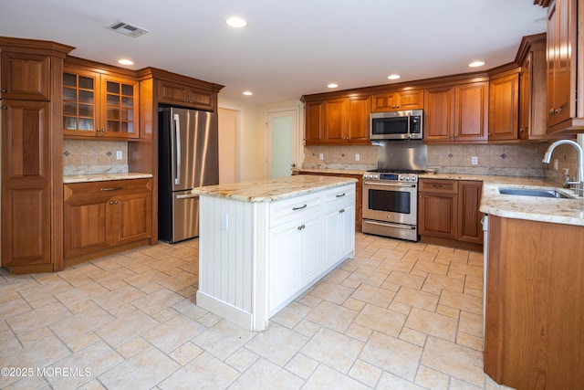 153 12th St, Belford, NJ 07718 - kitchen featuring appliances with stainless steel finishes, a sink, decorative backsplash, recessed lighting, and brown cabinets