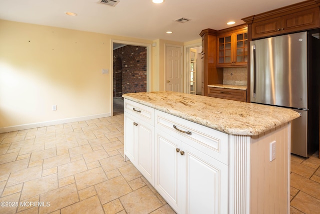 153 12th St, Belford, NJ 07718 - kitchen with freestanding refrigerator, glass insert cabinets, recessed lighting, a kitchen island, and light stone countertops